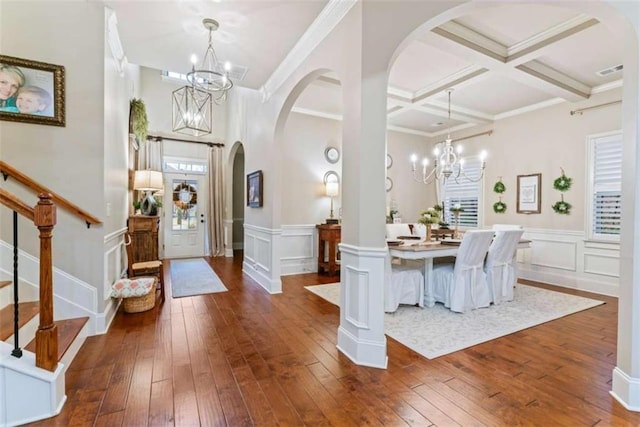 foyer entrance with an inviting chandelier, coffered ceiling, dark wood-style flooring, and beamed ceiling