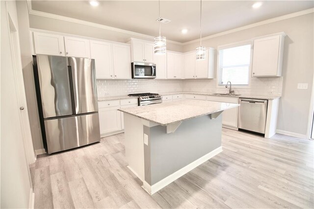 243 Hummingbird Trl, Dallas, GA 30132 - kitchen featuring appliances with stainless steel finishes, crown molding, a center island, tasteful backsplash, and recessed lighting