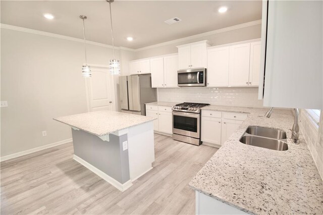 243 Hummingbird Trl, Dallas, GA 30132 - kitchen with appliances with stainless steel finishes, light wood finished floors, a center island, white cabinetry, and crown molding