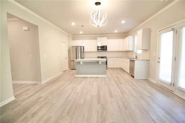 243 Hummingbird Trl, Dallas, GA 30132 - kitchen with stainless steel appliances, decorative backsplash, a center island, a chandelier, and ornamental molding