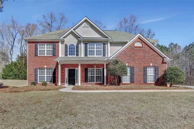 view of front of property featuring a front lawn and brick siding