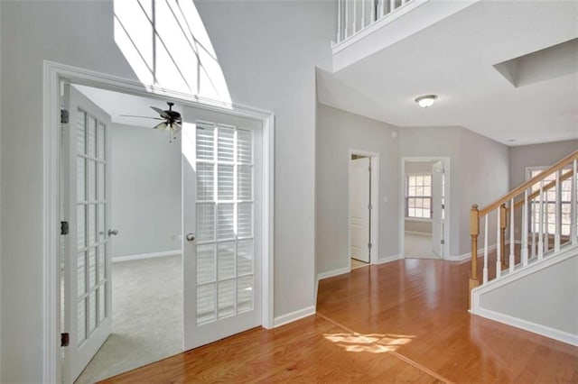 entryway featuring a skylight, stairs, baseboards, and wood finished floors