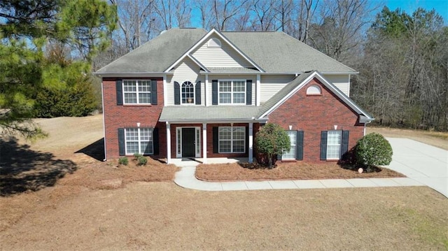 view of front of house featuring driveway and brick siding