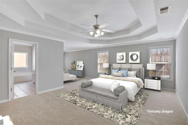 bedroom featuring a textured ceiling, a tray ceiling, and carpet