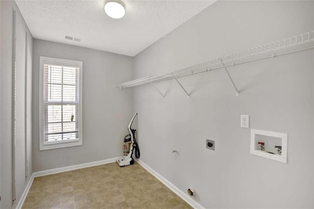 laundry room with a textured ceiling, hookup for a washing machine, laundry area, baseboards, and electric dryer hookup