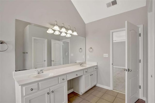 bathroom with double vanity, lofted ceiling, visible vents, a sink, and tile patterned flooring