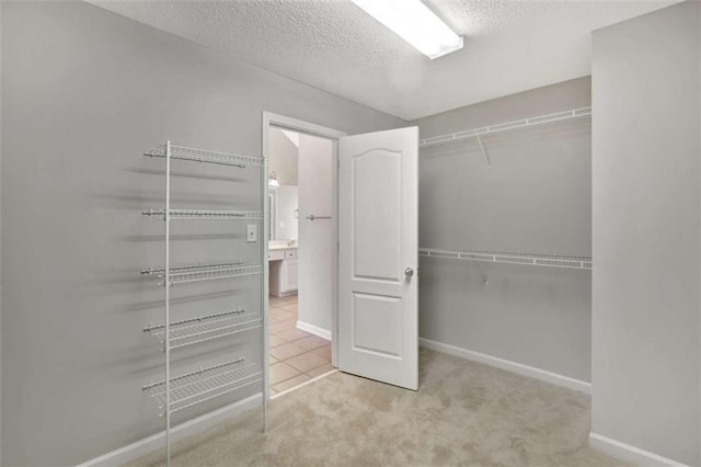 walk in closet featuring carpet and tile patterned flooring