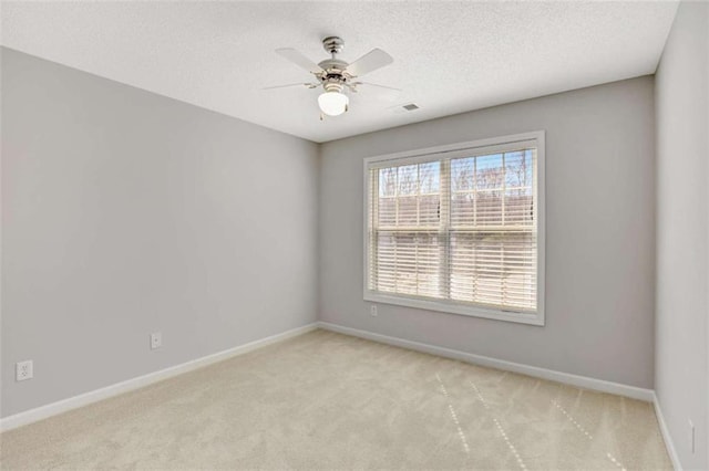 spare room with baseboards, visible vents, a ceiling fan, a textured ceiling, and carpet flooring