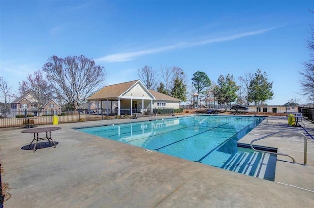 community pool with fence and a patio