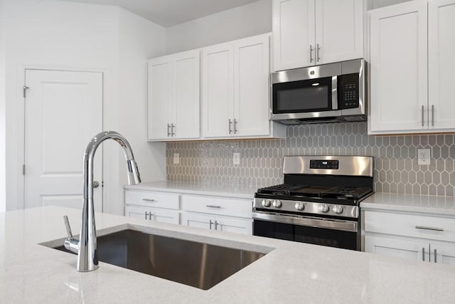 kitchen featuring white cabinets, backsplash, sink, and stainless steel appliances