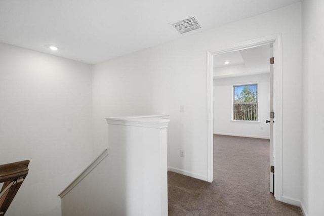 hallway with dark colored carpet