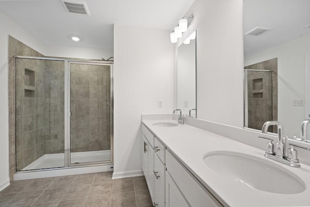 bathroom with an enclosed shower, vanity, and tile patterned floors