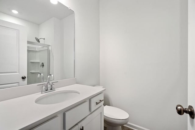 bathroom featuring toilet, vanity, and an enclosed shower