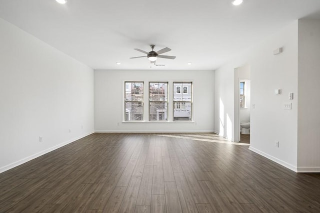 unfurnished room with ceiling fan and dark wood-type flooring