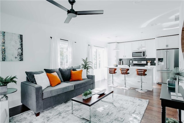 living room with ceiling fan and light wood-style floors