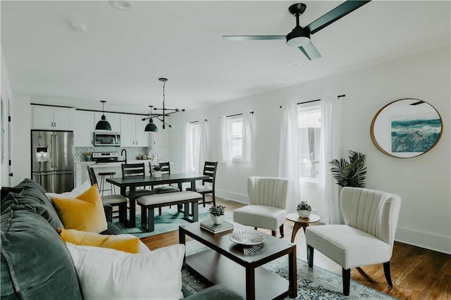 living area with baseboards, a chandelier, wood finished floors, a ceiling fan, and recessed lighting