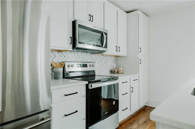 kitchen featuring stainless steel appliances, light countertops, dark wood-style flooring, and white cabinets