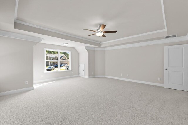 carpeted empty room with ceiling fan, ornamental molding, and a tray ceiling