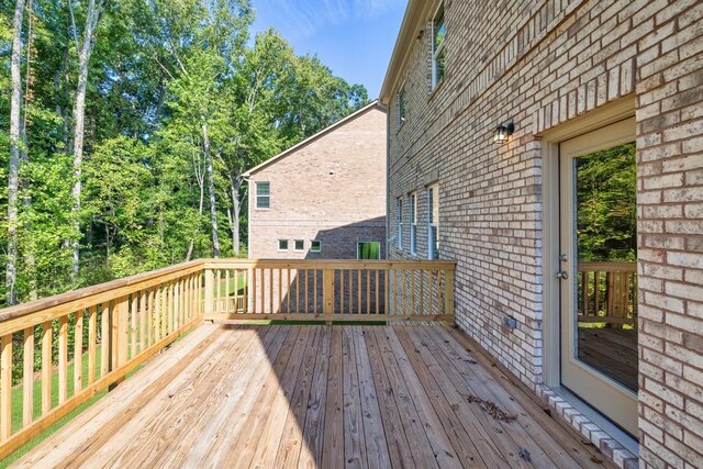 rear view of property with a deck and a lawn