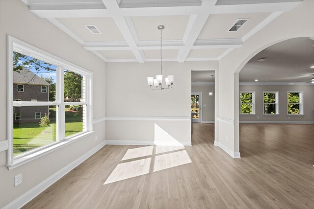 empty room featuring light wood-type flooring and ornamental molding