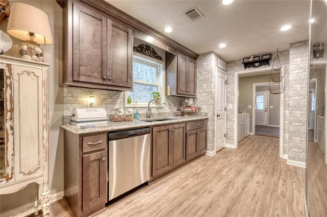 kitchen featuring sink, light stone counters, decorative backsplash, stainless steel dishwasher, and light wood-type flooring