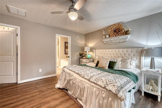 bedroom with hardwood / wood-style floors, ceiling fan, and ensuite bath