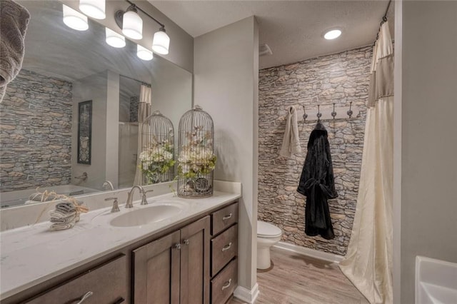 bathroom with hardwood / wood-style flooring, vanity, and toilet