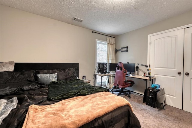 carpeted bedroom with a closet and a textured ceiling