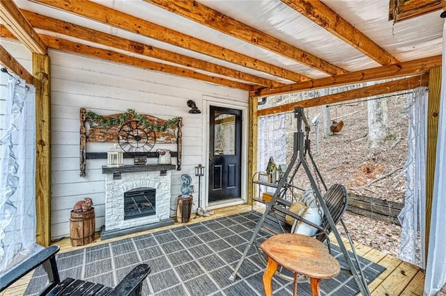 sunroom / solarium with a stone fireplace