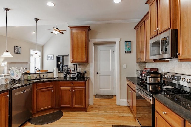 kitchen featuring appliances with stainless steel finishes, dark stone counters, brown cabinets, and a sink