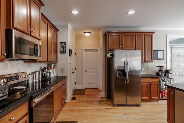 kitchen with stainless steel appliances, ornamental molding, light wood-style flooring, and decorative backsplash