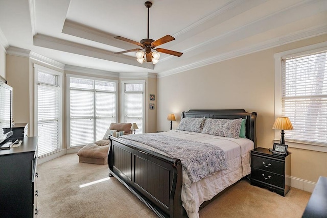 bedroom with light carpet, multiple windows, a tray ceiling, and crown molding