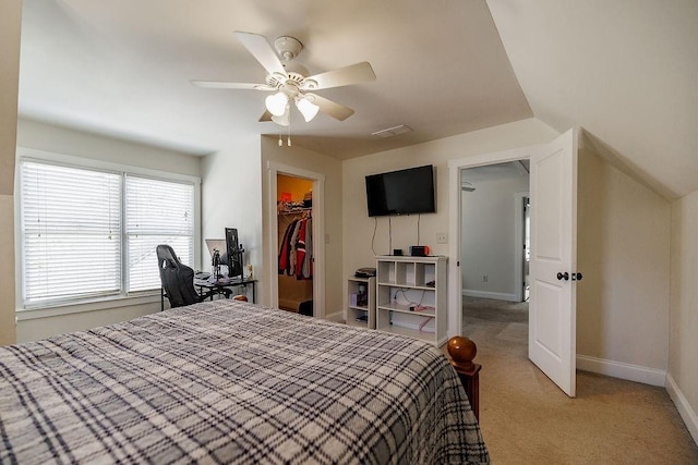 bedroom with a closet, a spacious closet, carpet flooring, ceiling fan, and baseboards