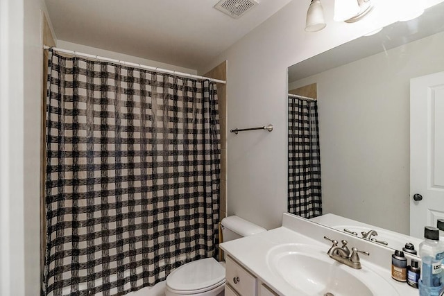 bathroom featuring a shower with shower curtain, visible vents, vanity, and toilet