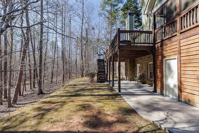 exterior space with a deck, a patio, brick siding, and stairway