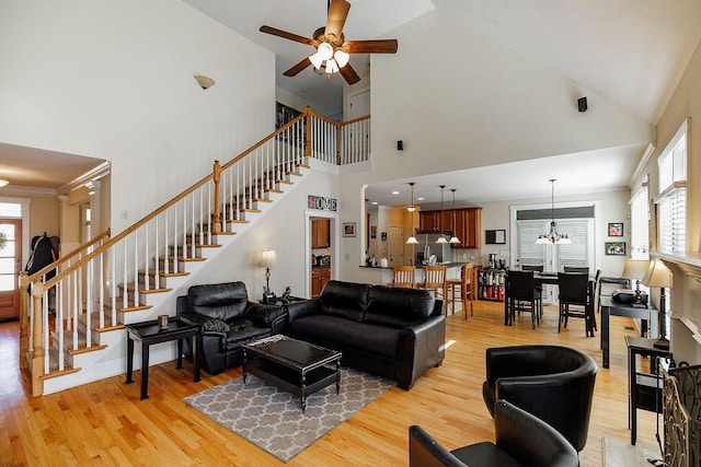 living area featuring light wood-style floors, stairway, and crown molding