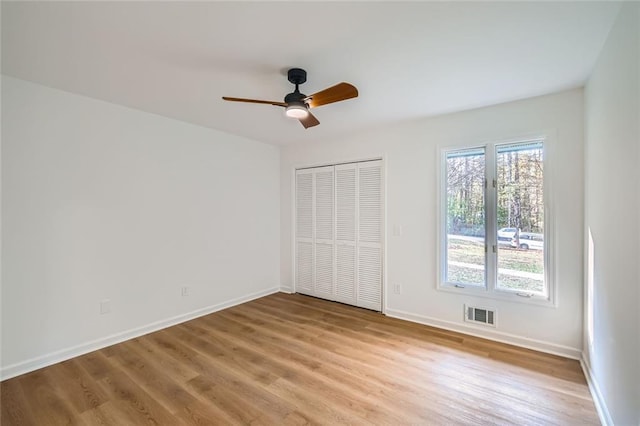 unfurnished bedroom featuring a closet, light hardwood / wood-style flooring, and ceiling fan