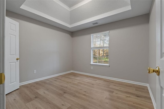 4625 Thermal Ct, Douglasville, GA 30135 - spare room featuring a tray ceiling, visible vents, baseboards, and light wood-style floors