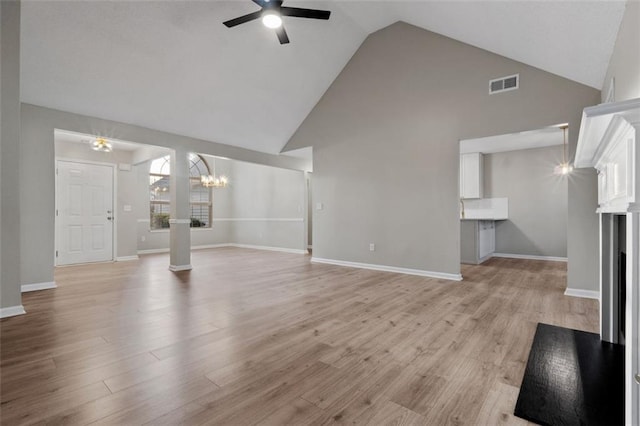 4625 Thermal Ct, Douglasville, GA 30135 - unfurnished living room with high vaulted ceiling, light wood-style flooring, ceiling fan with notable chandelier, baseboards, and visible vents