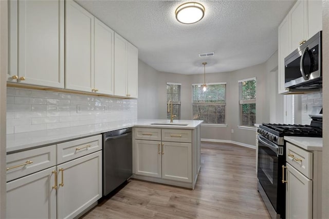 4625 Thermal Ct, Douglasville, GA 30135 - kitchen with a sink, light countertops, stainless steel appliances, a peninsula, and visible vents