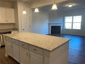 kitchen with pendant lighting, white cabinets, dishwasher, and a center island