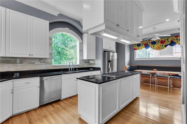470 Manor Oak Ln SE, Marietta, GA 30067 - kitchen with stainless steel appliances, a sink, white cabinets, a kitchen island, and light wood finished floors
