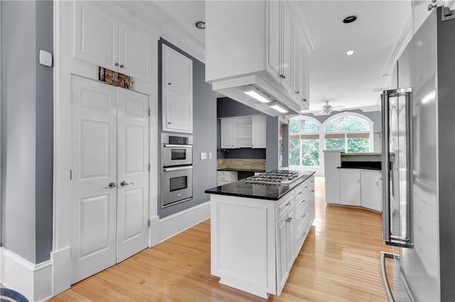 470 Manor Oak Ln SE, Marietta, GA 30067 - kitchen featuring appliances with stainless steel finishes, a kitchen island, white cabinets, light wood-style floors, and dark countertops