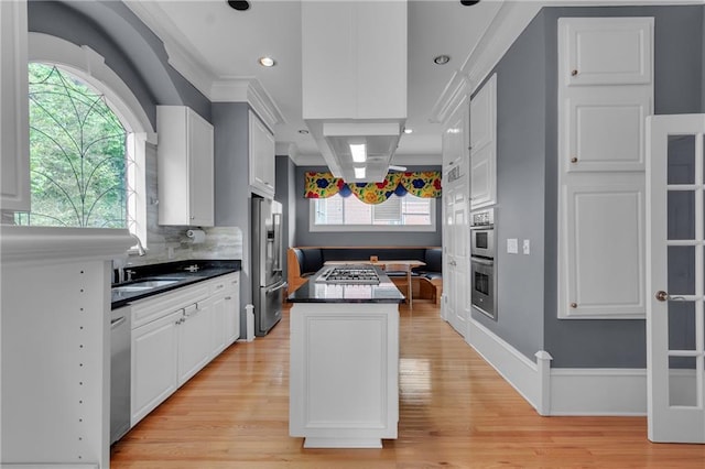 470 Manor Oak Ln SE, Marietta, GA 30067 - kitchen with appliances with stainless steel finishes, a kitchen island, a sink, light wood finished floors, and dark countertops