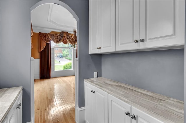 470 Manor Oak Ln SE, Marietta, GA 30067 - kitchen with white cabinetry, light countertops, arched walkways, and light wood-type flooring