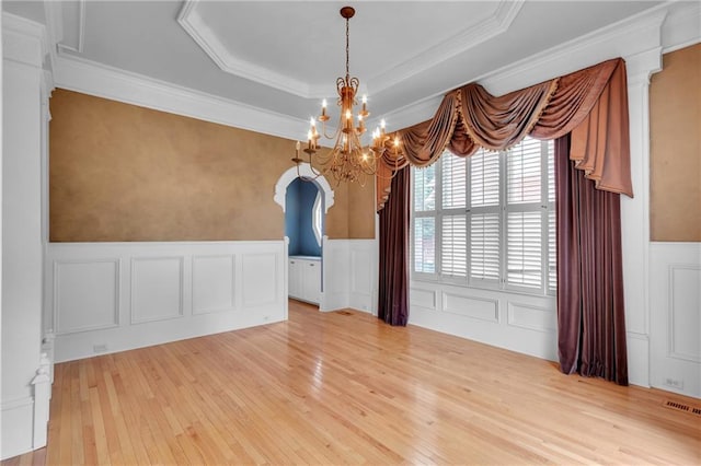 470 Manor Oak Ln SE, Marietta, GA 30067 - unfurnished dining area featuring wood-type flooring, a chandelier, a wainscoted wall, a decorative wall, and a raised ceiling