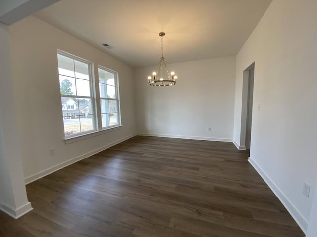 unfurnished dining area featuring a chandelier and dark hardwood / wood-style floors