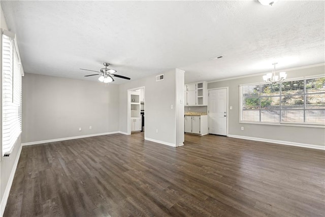 unfurnished living room featuring ceiling fan with notable chandelier, dark hardwood / wood-style flooring, and a textured ceiling