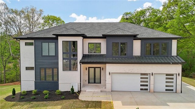 155 Westbrook St, Buford, GA 30518 - view of front of house featuring metal roof, a garage, concrete driveway, stucco siding, and a standing seam roof