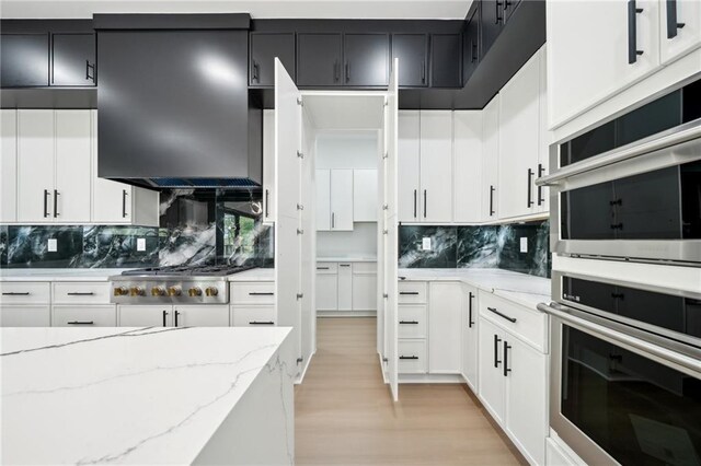 155 Westbrook St, Buford, GA 30518 - kitchen with white cabinets, light wood-style flooring, appliances with stainless steel finishes, and ventilation hood